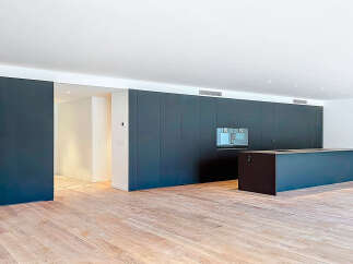 This modern kitchen boasts sleek, dark cabinetry and a spacious island, perfect for both cooking and entertaining.