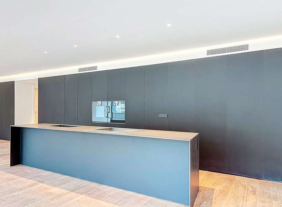 This modern kitchen boasts sleek, dark cabinetry and a spacious island, perfect for both cooking and entertaining.