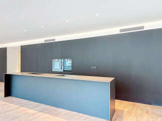 This modern kitchen boasts sleek, dark cabinetry and a spacious island, perfect for both cooking and entertaining.