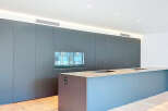 This modern kitchen boasts sleek, minimalist design with integrated appliances and ample storage.
