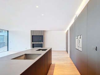 This modern kitchen boasts sleek, minimalist design with a large island and integrated appliances.
