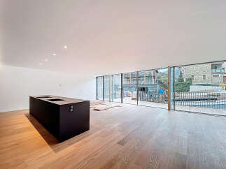 Experience modern living in this stunning property featuring a sleek, black kitchen island and expansive windows that flood the space with natural light.