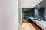 Step into luxury with this stunning bathroom featuring sleek black marble walls and a modern floating sink.