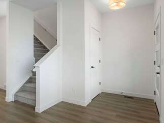Step into this beautifully designed home featuring a modern staircase and a welcoming entryway.