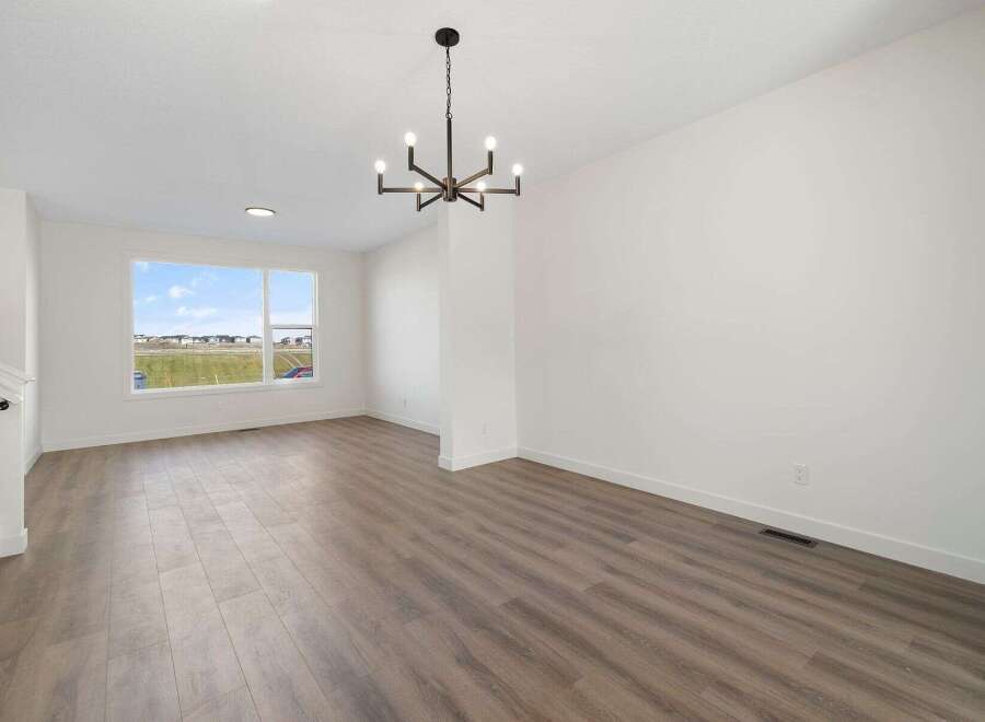 Step into this bright and airy living space, featuring a modern chandelier and ample natural light.