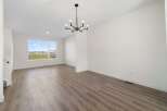 Step into this bright and airy living space, featuring a modern chandelier and ample natural light.