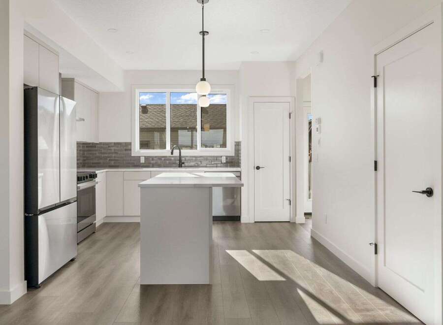 This stunning kitchen boasts a modern design with sleek white cabinetry and stainless steel appliances.