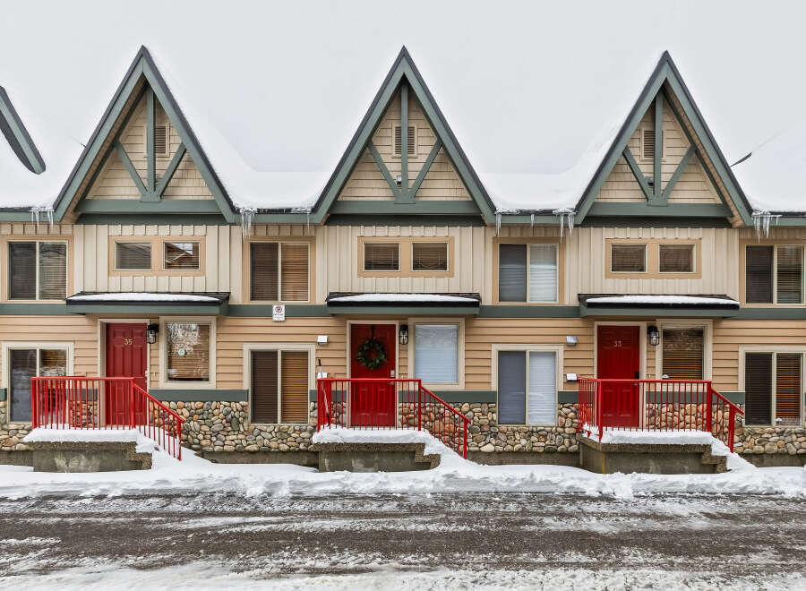 Charming townhomes nestled in a winter wonderland, perfect for a cozy retreat.