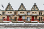 Charming townhomes nestled in a winter wonderland, perfect for a cozy retreat.
