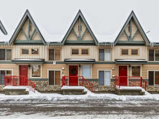 Charming townhomes nestled in a winter wonderland, perfect for a cozy retreat.