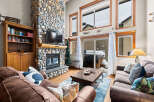 This stunning living room boasts a magnificent stone fireplace, creating a cozy and inviting atmosphere.
