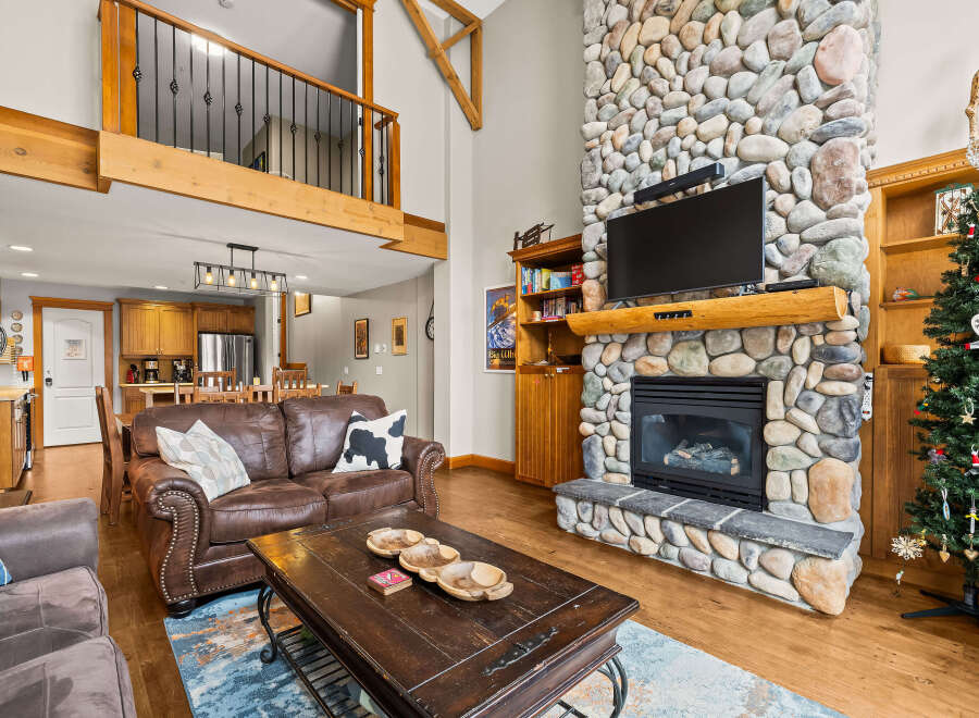 This stunning property boasts a cozy living room with a stone fireplace, perfect for relaxing evenings.