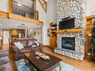 This stunning property boasts a cozy living room with a stone fireplace, perfect for relaxing evenings.