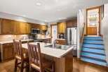 This stunning kitchen boasts beautiful wooden cabinetry and a spacious island, perfect for both cooking and entertaining.