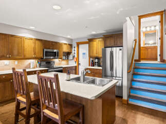 This stunning kitchen boasts beautiful wooden cabinetry and a spacious island, perfect for both cooking and entertaining.