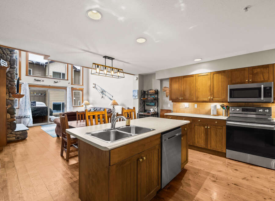 This stunning kitchen boasts a spacious island with a double sink and a modern stainless steel dishwasher.