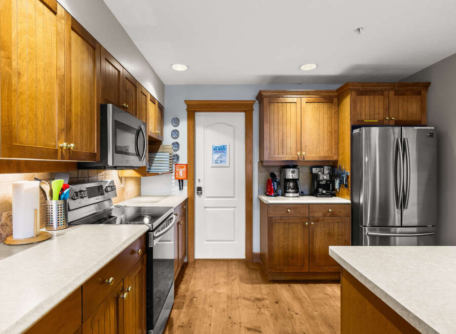 This stunning kitchen boasts beautiful wooden cabinetry and modern stainless steel appliances, creating a warm and inviting atmosphere.