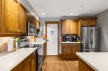 This stunning kitchen boasts beautiful wooden cabinetry and modern stainless steel appliances, creating a warm and inviting atmosphere.