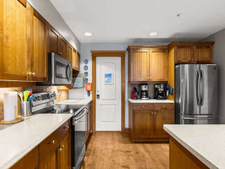 This stunning kitchen boasts beautiful wooden cabinetry and modern stainless steel appliances, creating a warm and inviting atmosphere.