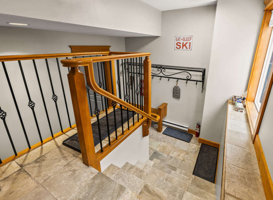 This stunning entryway features a beautiful staircase with a wooden railing and intricate wrought iron details.