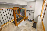 This stunning entryway features a beautiful staircase with a wooden railing and intricate wrought iron details.