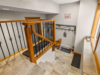 This stunning entryway features a beautiful staircase with a wooden railing and intricate wrought iron details.