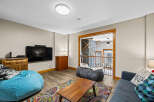 This cozy living space features a modern entertainment setup with a large flat-screen TV and a stylish soundbar.