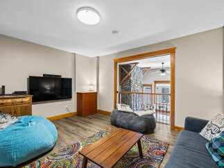 This cozy living space features a modern entertainment setup with a large flat-screen TV and a stylish soundbar.