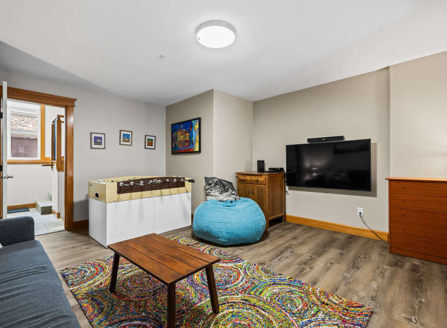This inviting living space features a cozy seating area with a vibrant rug and a comfortable beanbag chair.