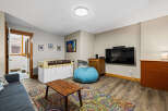 This inviting living space features a cozy seating area with a vibrant rug and a comfortable beanbag chair.