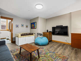 This inviting living space features a cozy seating area with a vibrant rug and a comfortable beanbag chair.