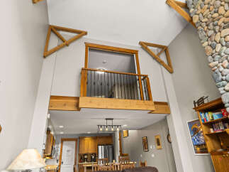 This stunning property boasts a unique architectural design with high ceilings and exposed wooden beams, creating a spacious and inviting atmosphere.