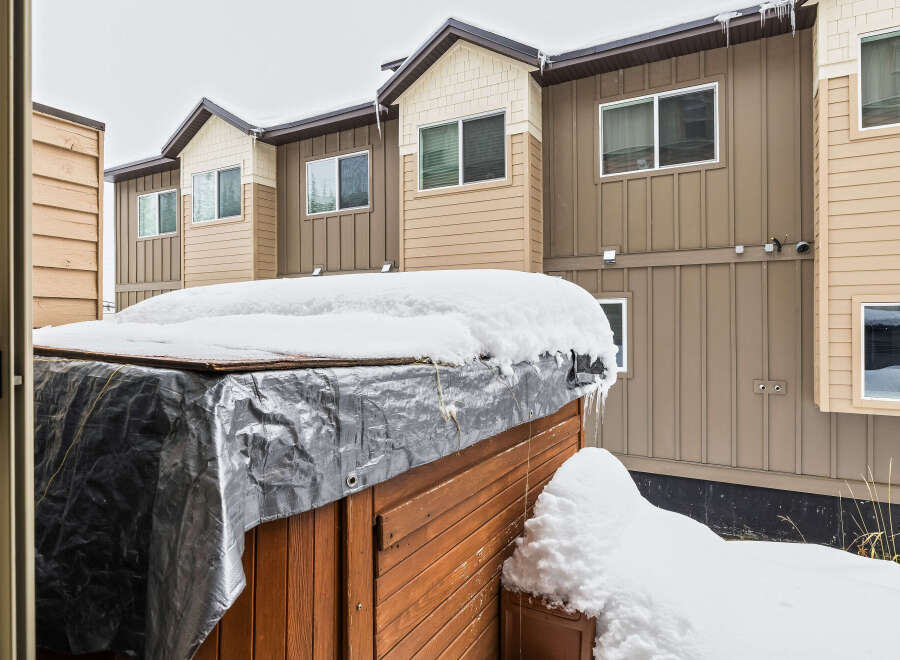 This stunning property boasts a beautiful exterior with a charming wooden hot tub, perfect for relaxing in the winter.