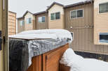 This stunning property boasts a beautiful exterior with a charming wooden hot tub, perfect for relaxing in the winter.