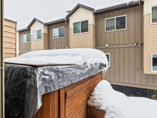 This stunning property boasts a beautiful exterior with a charming wooden hot tub, perfect for relaxing in the winter.