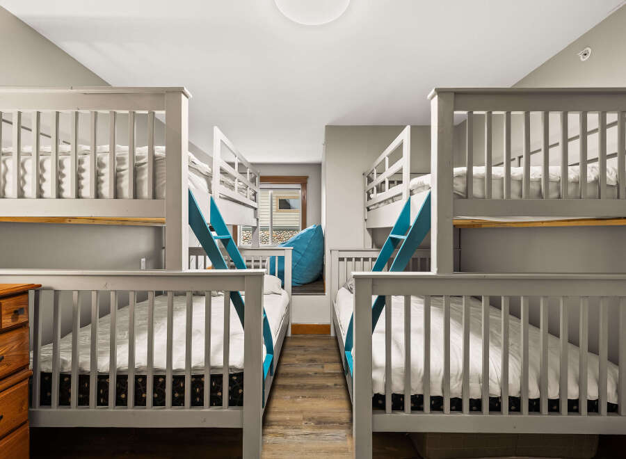 This charming bedroom features two sets of bunk beds, perfect for accommodating multiple guests or family members.