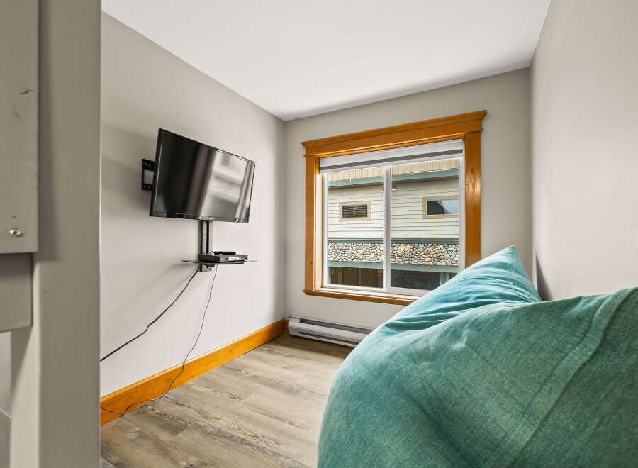 Cozy up in this inviting space! This room features a mounted TV, perfect for entertainment, and a comfortable beanbag chair.