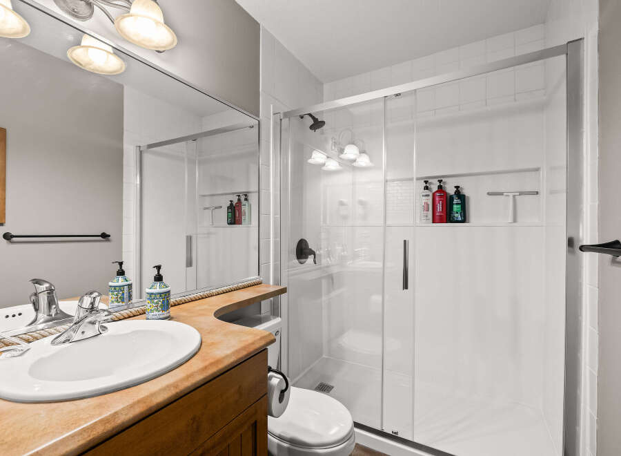 Step into this beautifully designed bathroom featuring a modern glass shower and a stylish vanity.