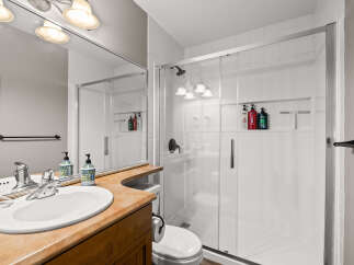 Step into this beautifully designed bathroom featuring a modern glass shower and a stylish vanity.