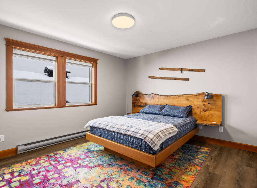 This cozy bedroom features a unique wooden headboard and bed frame, creating a warm and inviting atmosphere.