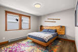 This cozy bedroom features a unique wooden headboard and bed frame, creating a warm and inviting atmosphere.