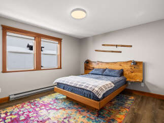 This cozy bedroom features a unique wooden headboard and bed frame, creating a warm and inviting atmosphere.