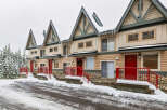 Charming townhomes nestled in a winter wonderland, offering a cozy retreat with stunning curb appeal.