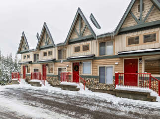 Charming townhomes nestled in a winter wonderland, offering a cozy retreat with stunning curb appeal.