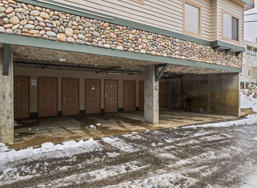This property features a unique stone facade and covered parking, offering both aesthetic appeal and practicality.
