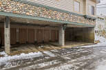 This property features a unique stone facade and covered parking, offering both aesthetic appeal and practicality.