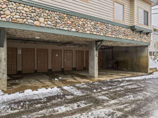 This property features a unique stone facade and covered parking, offering both aesthetic appeal and practicality.