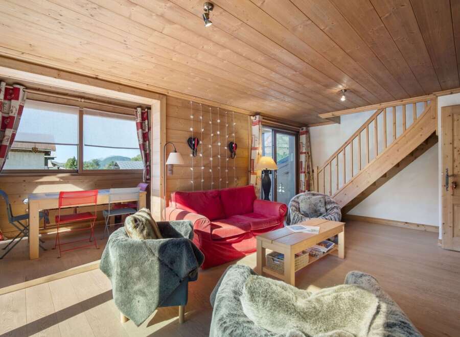 This cozy living space features a warm, inviting atmosphere with its wooden paneling and natural light.