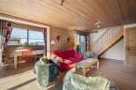 This cozy living space features a warm, inviting atmosphere with its wooden paneling and natural light.