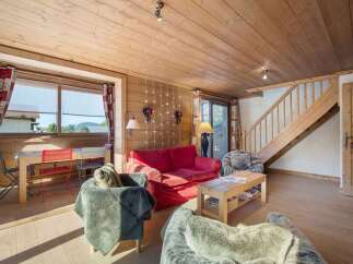 This cozy living space features a warm, inviting atmosphere with its wooden paneling and natural light.